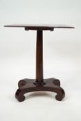 A William IV mahogany tilt top table on waisted rectangular base, issuing from scroll feet,