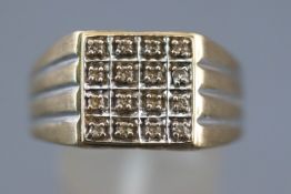 A yellow metal signet ring illusion set with round brilliant cut diamonds