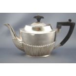 A silver bachelor's tea pot of usual oval ribbed form with domed lid on a concave top