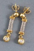 A yellow and white metal pair of drop earrings.