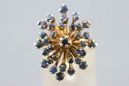 A yellow metal spray cluster ring set with round faceted cut sapphires