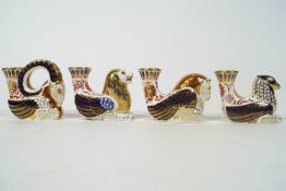 Four Royal Crown Derby Imari candlesticks in the form of a griffin, a ram, a bull and a lion,