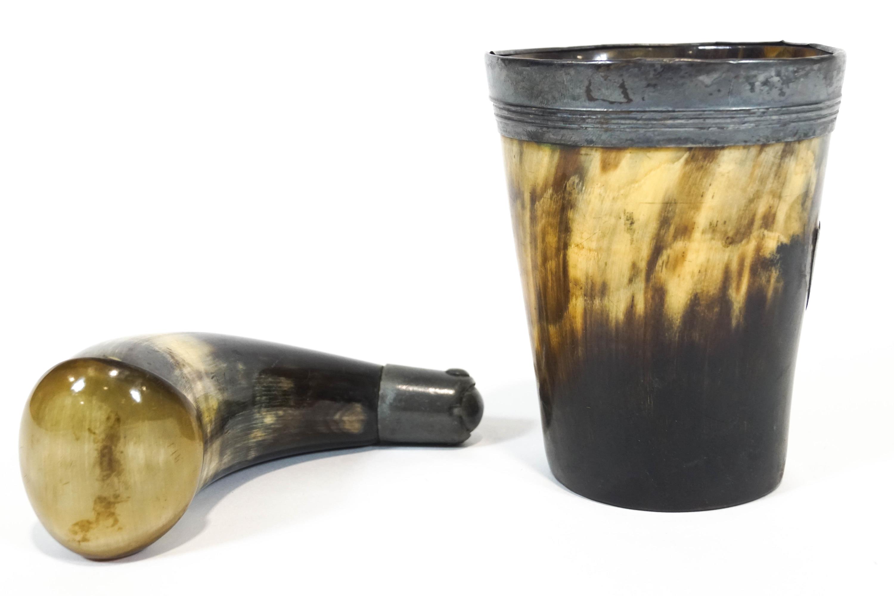 A worked horn powder flask with a pewter measure dispenser,