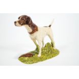 A Royal Doulton china figure of a Pointer standing on a grassy mount with a pheasant