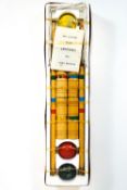 A boxed four player croquet set with wooden mallets,
