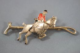 A costume jewellery stock pin in the form of a crop with jumping huntsman, overall 6.