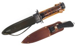 A leather handled dagger in a metal and leather belt/leg scabbard with gun clip attachment to the