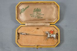 A yellow and white metal bar brooch depicting a horse and fox