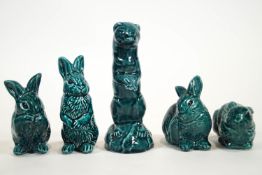 A blue glazed Poole pottery family of four rabbit figures and a weasel,