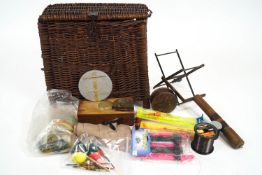 An early wicker fishing basket and contents together with a fishing line winder/drier