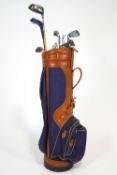 A Burton Canvas and Vinyl golf bag with an assortment of clubs and balls