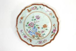 A late 18th century Chinese export porcelain plate, painted in the famille verte with iron red rim,