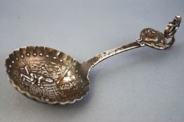 A white metal caddy spoon,