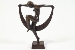 A bronze dancer, in the high Art Deco style, showing a naked lady with her leg and arms up,