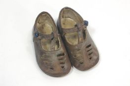 A pair of Children's leather shoes, of pierced sandal form with button down strap and leather soles,