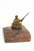 A Bergman style figure in cold painted bronze showing a moor in a squatting position,