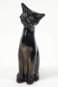 A Barnstaple pottery cat, seen in a seated pose with his head on one side,