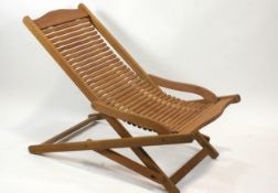 A pair of teak folding garden chairs, with horizontal slats to the seat and back,