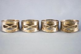 A group of four silver pierced and spot hammer decorated Arts & Crafts style napkin rings