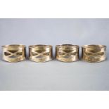 A group of four silver pierced and spot hammer decorated Arts & Crafts style napkin rings