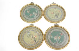 A set of four Chinese silkwork circular pictures, each with flowering branches within three borders,