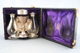 A cased silver travelling Communion set, comprising a Chalice, paten Pyx and two cruets,