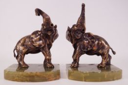 A pair of brass book ends with bronze patinated elephants,