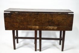 A Provincial elm wood plank drop leaf gateleg table of plain form,