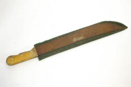 A machete, with wooden handle, set in a green canvas case,