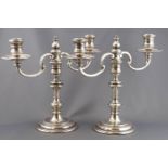 A pair of loaded silver George III style candlesticks with detachable two branch candelabra