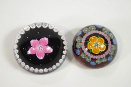Two paperweights in glass, with millefiori cane work, each set a central five petal flower,