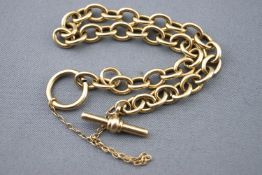 A yellow metal trace link bracelet with Tbar and loop clasp and fitted safety chain.