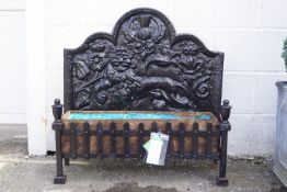 A cast iron fire back with attendant attached log basket