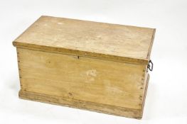 A pine blanket box with two iron handles and plinth base,