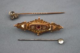 A yellow metal bar brooch set rubies and rose cut diamonds with a glazed locket section to reverse.