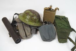 A group of assorted militaria, to include a tin hat, water flask, wooden rattle, webbing belts,