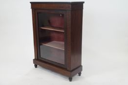 A 19th century mahogany pier cabinet, the glazed door opening to reveal two shelves,