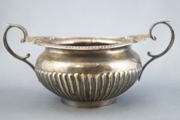 A silver two handled sugar bowl of Regency form with leaf capped and foliate decorated terminals