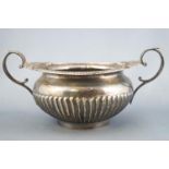 A silver two handled sugar bowl of Regency form with leaf capped and foliate decorated terminals