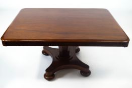 A William IV mahogany breakfast table, on waisted rectangular base and bun feet enclosing casters,