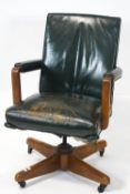 A mid 20th century leather swivel office chair, the back and seat upholsterd in green leather,