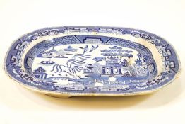 A 19th century pottery meat platter, printed in blue with the Willow pattern,