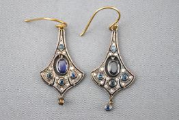 A yellow and white metal pair of drop earrings.