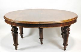 A Victorian mahogany dining table on turned and fluted tapering legs,