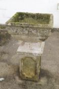 A reconstituted stone urn and stand
