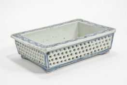 A Chinese porcelain rectangular shallow bowl with reticulated sides on bracket style feet,