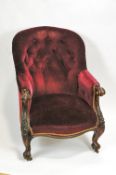 A Victorian button back armchair on carved cabriole legs and casters,