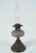 A Victorian oil lamp,the milk glass reservoir painted in white enamel with grapes and flowers,