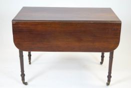 A 19th century mahogany Pembroke table on turned tapering legs,