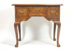 A George II style walnut low boy with three frieze drawers on cabriole legs with pad feet,